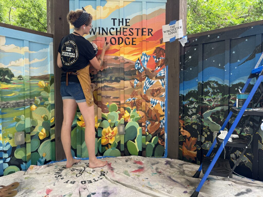 Kate Cook paints a mural at the Winchester Lodge